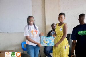 Jennifer Addo presenting an package to the Girls School Prefect of Korle Gonno Methodist School A