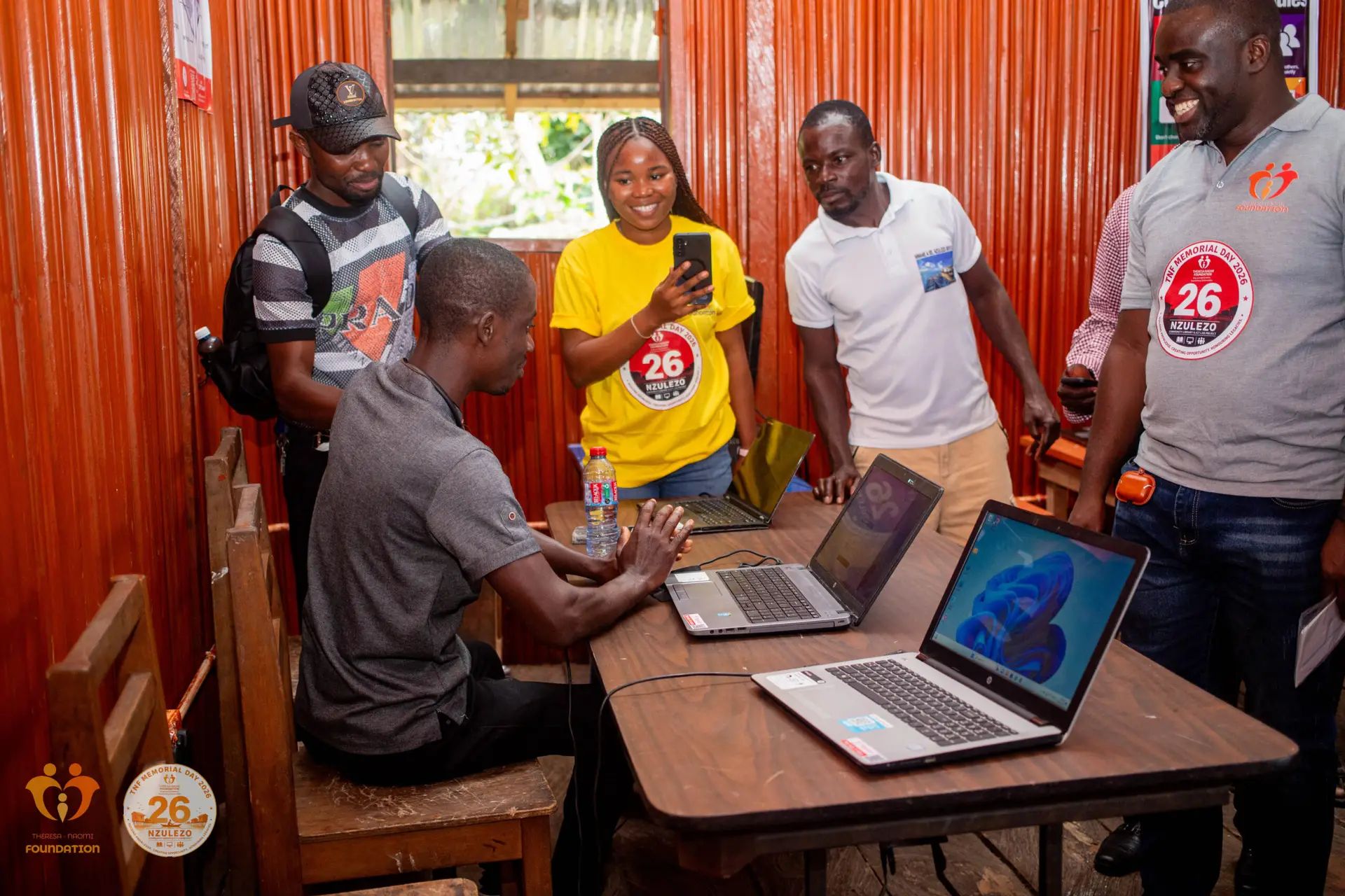 Commissioning visitors gathered around laptops in the ICT lab at TNF Hub – Nzulezo.
